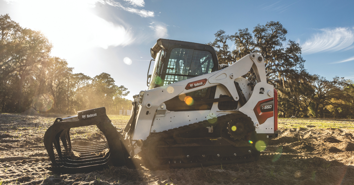 Land clearing equipment working on a job site in fall with a blue sky