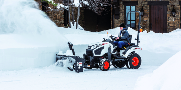 Bobcat tractor using a snow blower for winter snow removal