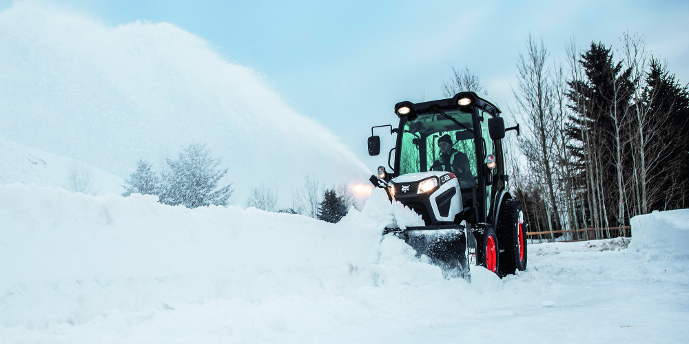 bobcat tractor with snow blower attachment pushing snow to the side